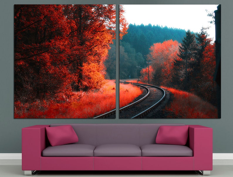 K&ouml;nnte beinhalten: Ein zweiteiliger Leinwanddruck mit einer malerischen Landschaft, auf der sich ein Bahngleis durch einen Wald schl&auml;ngelt. Das linke Panel zeigt eine Nahaufnahme von roten und orangen B&auml;umen, w&auml;hrend das rechte Panel eine weitere Ansicht des Gleises mit einem Wald im Hintergrund zeigt.