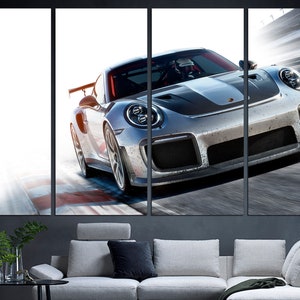 May include: A silver grey Porsche 911 GT2 RS sports car speeding on a race track. The car has a black stripe running down the center of the hood and a black rear wing.