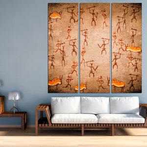 May include: A three-panel canvas print depicting a cave painting style image of stick figures hunting animals. The figures are brown and orange, and the background is a textured beige.