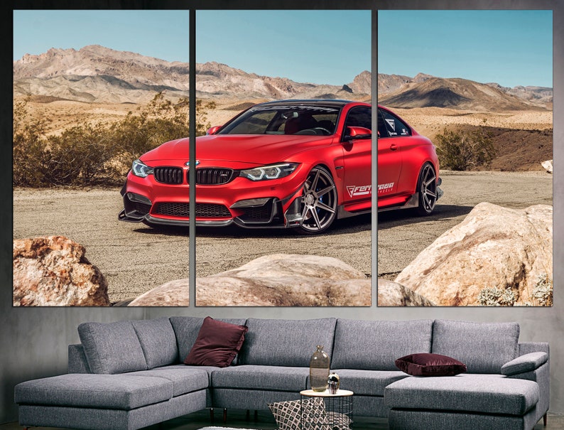 May include: A red BMW M4 sports car with black accents and black wheels is parked on a dirt road in a desert landscape. The car has a "Forged" sticker on the side.