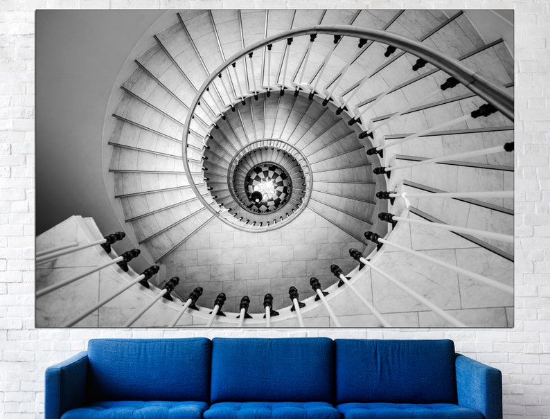 May include: A black and white photograph of a spiral staircase with a white railing. The staircase is made of marble and has a checkered pattern at the bottom.