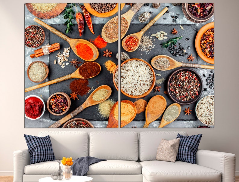 May include: A close-up image of various spices and grains in wooden spoons and bowls on a dark gray surface. The spices include black peppercorns, red pepper flakes, cumin, and cinnamon sticks. The grains include rice and quinoa.