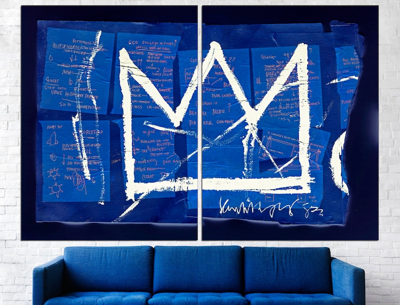 May include: A white crown painted on a blue background with handwritten notes and a signature. The crown is a simple design with a pointed top and a rounded base. The notes are in blue ink and are mostly illegible. The signature is in black ink and reads "Kaws 93".