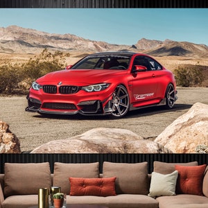 May include: A red BMW M4 sports car with black wheels and a "Ferrada Wheels" sticker on the side, parked in a desert landscape.