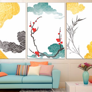 Pu&ograve; includere: Un set di tre stampe d'arte astratte con nuvole dorate, nere e turchesi con fiori rossi e rami di bamb&ugrave; su uno sfondo bianco.