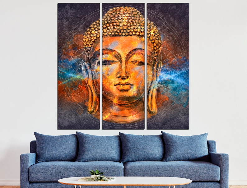 May include: A triptych canvas art piece featuring a serene Buddha head. The artwork showcases warm orange and gold tones, with a textured appearance. Blue and orange abstract elements surround the Buddha's head, creating a spiritual and artistic ambiance.