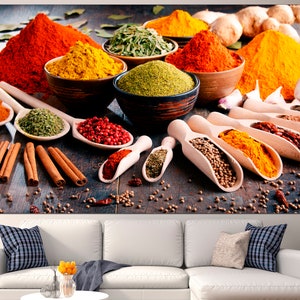 May include: A variety of spices in bowls and spoons on a wooden surface. The spices include red pepper flakes, turmeric, paprika, cumin, coriander, and cinnamon sticks.