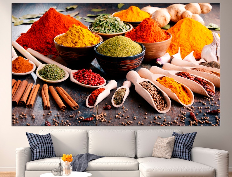 May include: A variety of spices in bowls and spoons on a wooden surface. The spices include red pepper flakes, turmeric, paprika, cumin, coriander, and cinnamon sticks.