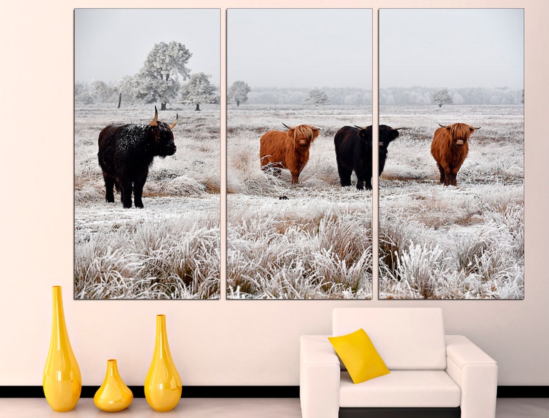 May include: A triptych canvas print featuring four Highland cattle standing in a snowy field. The cattle are brown and black with long horns. The field is covered in white snow and frost.