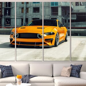 May include: A bright yellow sports car parked in a concrete car park. The car has a black grille and black wheels. The car is in focus, while the background is blurred.