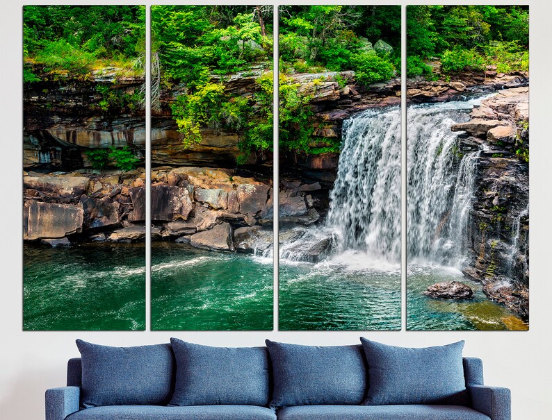 May include: A multi-panel canvas print featuring a waterfall cascading over moss-covered rocks and into a clear pool of water. The lush green foliage surrounding the waterfall adds a touch of natural beauty to the scene.