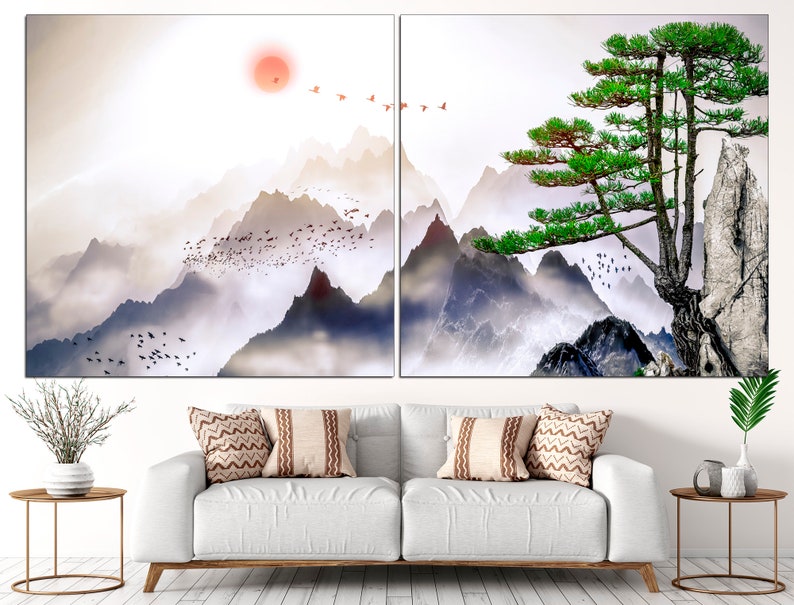 May include: A split canvas print featuring a misty mountain landscape with a single green pine tree on a rocky cliff. The sky is a soft white with a red sun in the distance.