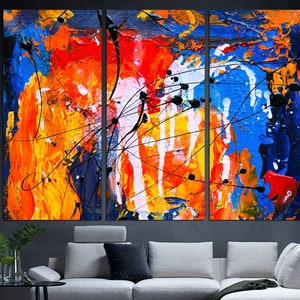 May include: Abstract art triptych canvas wall art with a colorful design of blue, red, orange, yellow, and white paint splatters and lines.