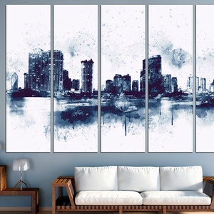 May include: A watercolor painting of a city skyline in shades of blue and white. The painting is divided into four panels, each depicting a different section of the city. The buildings are tall and slender, and the water is calm and reflective.