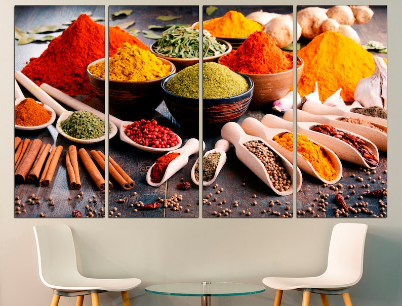 May include: A collection of various spices in bowls and spoons, including red, yellow, green, and brown spices. The spices are arranged on a wooden surface with cinnamon sticks and other spices scattered around.