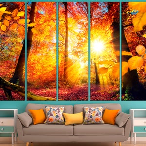 May include: A five-panel canvas print depicting a forest scene with vibrant autumn foliage in shades of orange, yellow, and red. Sunlight streams through the trees, creating a warm and inviting atmosphere.