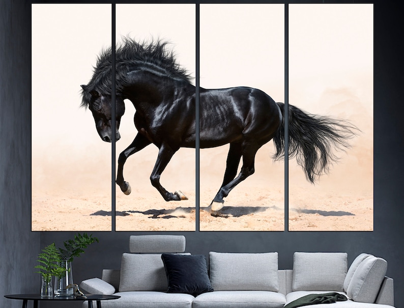 May include: A black horse runs across a sandy surface with its mane and tail flowing in the wind. The horse is in sharp focus against a white background.