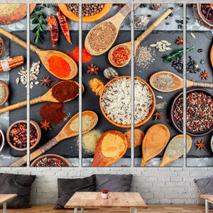 May include: A close-up of various spices and grains in wooden spoons and bowls on a black slate background. The spices include black peppercorns, cumin seeds, coriander seeds, and red pepper flakes. The grains include rice, quinoa, and couscous.