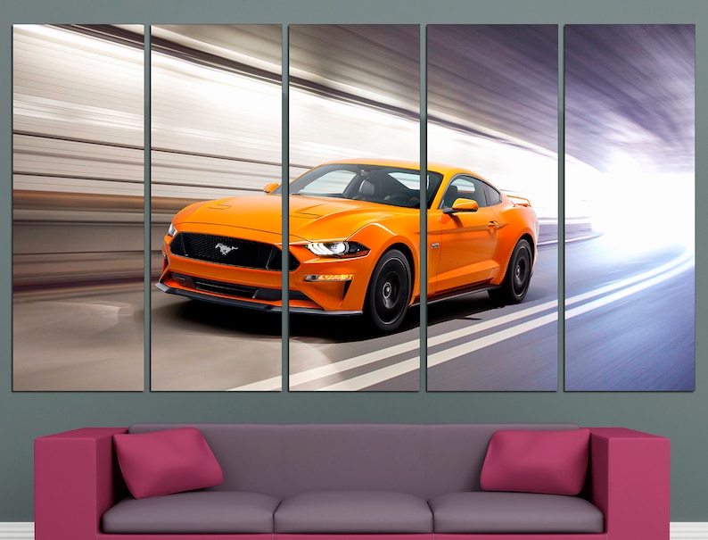 May include: A bright orange Ford Mustang sports car speeding through a tunnel with white lines on the road.