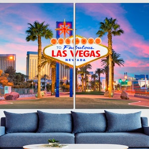 May include: A two-panel canvas print featuring the iconic "Welcome to Fabulous Las Vegas" sign. The sign is white with yellow lights and a red star, set against a vibrant sunset sky. Palm trees and city buildings frame the scene.