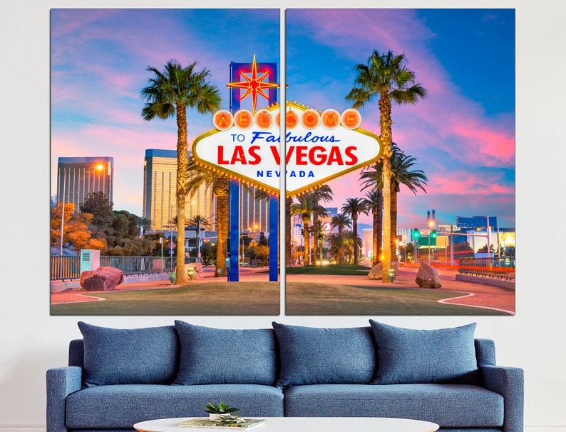 May include: A two-panel canvas print featuring the iconic "Welcome to Fabulous Las Vegas" sign. The sign is white with yellow lights and a red star, set against a vibrant sunset sky. Palm trees and city buildings frame the scene.