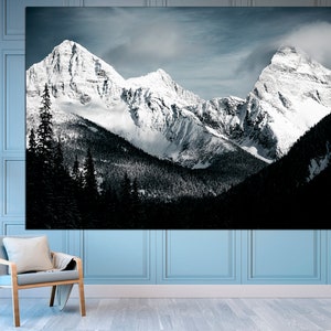 Puede incluir: Una fotograf&iacute;a en blanco y negro de monta&ntilde;as cubiertas de nieve con un bosque en primer plano.