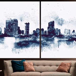 May include: A watercolor painting of a city skyline in shades of blue and white. The buildings are silhouetted against a white background, and there are splashes of blue paint throughout the image.