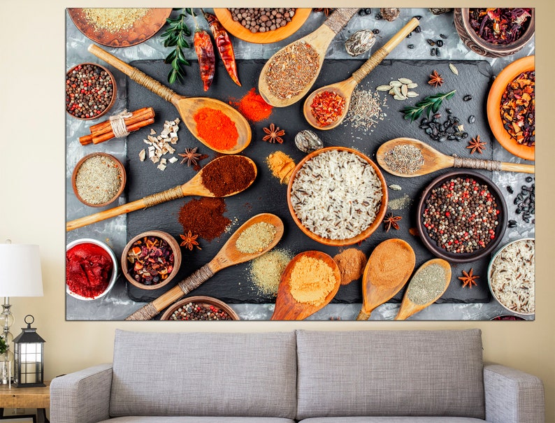 May include: A flat lay image of various spices and grains in bowls and spoons on a dark gray surface. The spices include black peppercorns, red pepper flakes, cumin, and coriander. The grains include rice and quinoa. The spoons are wooden and have a natural finish.