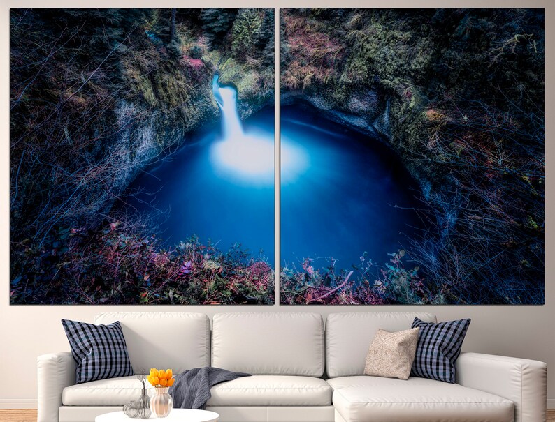 May include: A split canvas print of a waterfall cascading into a deep blue pool surrounded by lush greenery. The image is taken from a low angle, giving the viewer a sense of being immersed in the scene.