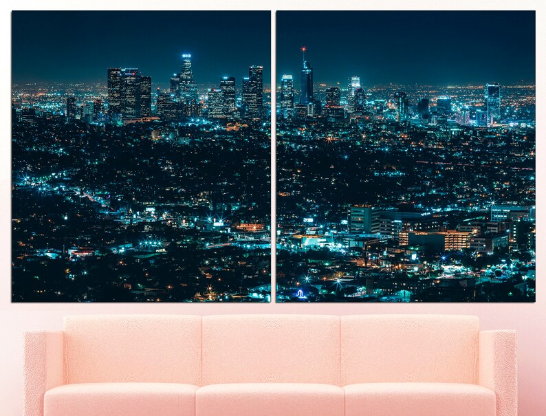 Puede incluir: Una vista panor&aacute;mica nocturna de un horizonte urbano con edificios altos iluminados por luces. La ciudad se extiende hacia abajo, con muchos edificios m&aacute;s peque&ntilde;os y calles visibles. El cielo es azul oscuro y las luces crean un brillo c&aacute;lido.