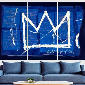 May include: A white crown painted on a blue background with white and pink handwritten notes. The crown is a simple design with a pointed top and a rounded base. The background is a collage of blue paper with white and pink handwritten notes.