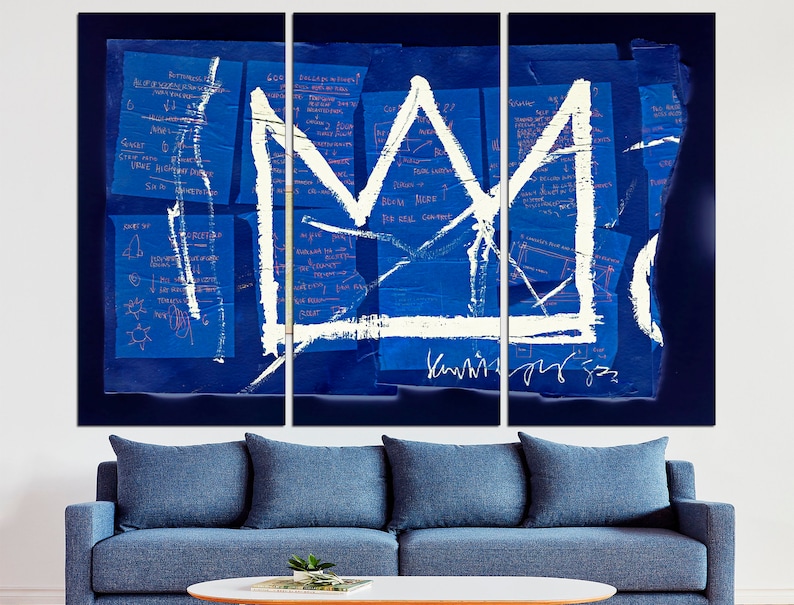 May include: A white crown painted on a blue background with white and pink handwritten notes. The crown is a simple design with a pointed top and a rounded base. The background is a collage of blue paper with white and pink handwritten notes.