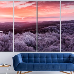 May include: A panoramic view of a winter forest at sunrise. The trees are covered in frost and the sky is a vibrant pink and orange. The sun is setting in the distance, casting a warm glow over the landscape.