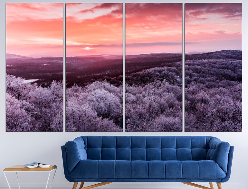 May include: A panoramic view of a winter forest at sunrise. The trees are covered in frost and the sky is a vibrant pink and orange. The sun is setting in the distance, casting a warm glow over the landscape.