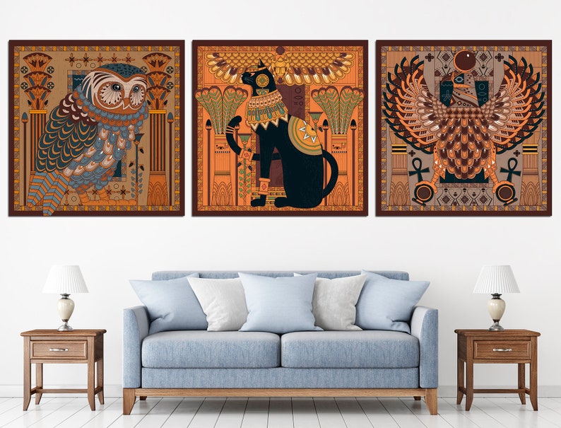 May include: Three framed prints with an Egyptian theme. The first print features an owl with intricate details, the second print features a black cat with a golden collar, and the third print features a winged creature with a golden crown.