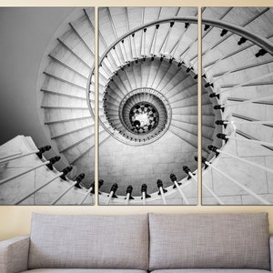May include: A black and white photograph of a spiral staircase. The staircase is made of white marble and has a black metal railing. The photo is split into three sections, showing the staircase from different angles.