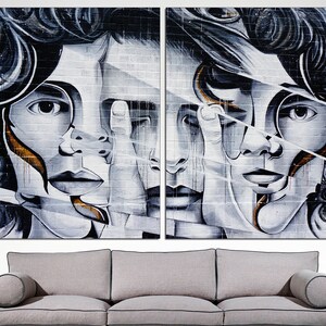 May include: A split-screen image of two abstract faces with black and white paint and gold accents on a brick wall background.