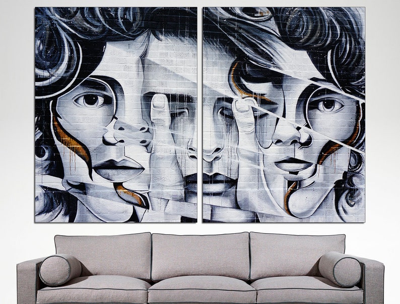 May include: A split-screen image of two abstract faces with black and white paint and gold accents on a brick wall background.