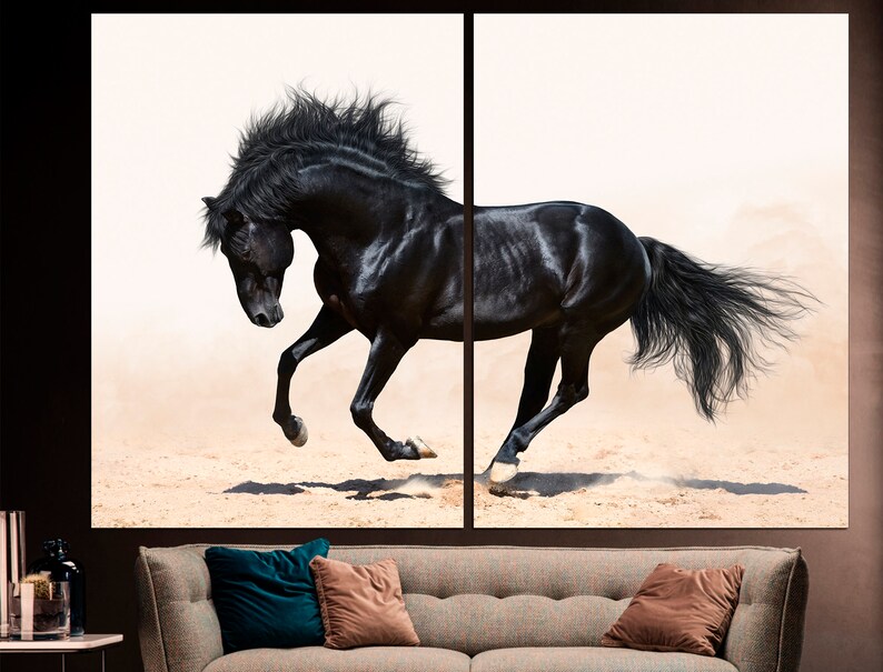 May include: A black horse with a flowing mane and tail runs across a sandy surface. The horse is in mid-stride, with its legs extended and its head held high. The background is a soft white.