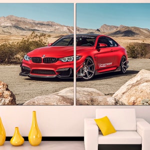 May include: A red BMW M4 sports car parked on a dirt road in a desert landscape. The car has black wheels and a black front splitter. The car has a "Forged" sticker on the side.