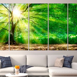 May include: A five-panel canvas print depicting a large tree with green leaves and sunbeams shining through the branches. The tree is in a forest setting with a green background.