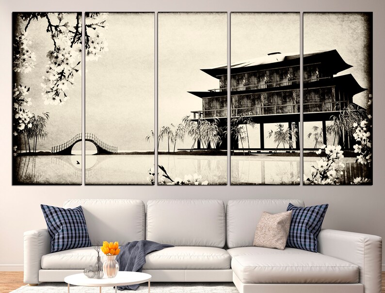May include: A black and white canvas print of a traditional Japanese house with a bridge and cherry blossoms. The house is on stilts over a body of water. The print is in a vintage style.