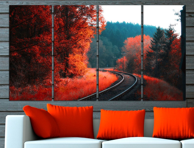 K&ouml;nnte beinhalten: Ein mehrteiliger Leinwanddruck, der eine malerische Eisenbahnstrecke zeigt, die sich durch einen Wald schl&auml;ngelt. Die B&auml;ume sind eine Mischung aus Gr&uuml;n und Rot, wobei die roten Bl&auml;tter eine lebendige Herbstszene erzeugen. Die Gleise befinden sich im Vordergrund, der Wald erstreckt sich im Hintergrund.