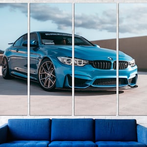 May include: A blue BMW M4 sports car parked on a concrete surface. The car has black wheels and a black front bumper.