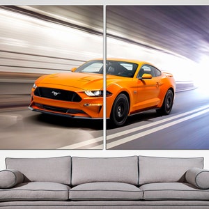 May include: A bright orange Ford Mustang sports car speeding through a tunnel. The car has black wheels and a black front grille with the Ford logo.
