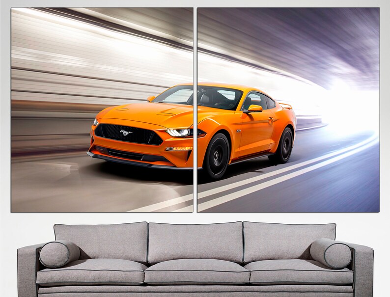May include: A bright orange Ford Mustang sports car speeding through a tunnel. The car has black wheels and a black front grille with the Ford logo.
