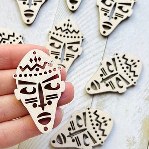 May include: Wooden tribal mask cutouts with intricate designs. The masks feature geometric patterns and facial features, including eyes, a nose, and a mouth. The masks are light brown in color and have a smooth finish. Ideal for crafting and decorative projects.