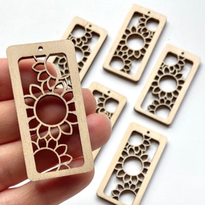 May include: Several rectangular wooden cutouts with a sunflower design. Each cutout has a rectangular frame with a sunflower design cut out of the center. The wood is a light, natural color.