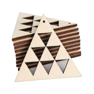 May include: A stack of unfinished wooden triangle shapes with cut-out triangles. Each triangle has a small hole at the top for hanging. The wood has a light, natural color with visible grain, and the edges are a darker brown.