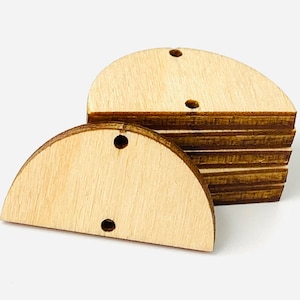 May include: A stack of unfinished wooden half-circle cutouts with pre-drilled holes for crafting. The natural wood grain is visible, and the shapes are stacked on a white background. These craft supplies are ideal for DIY projects.